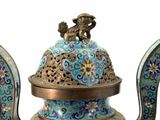 a blue and gold vase with a bird on top