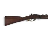 un fusil avec un canon en bois et des garnitures en laiton sur fond blanc