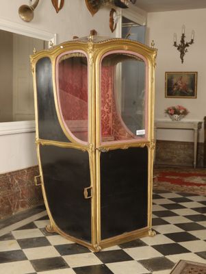 a black and white checkered floor with a gold and red carriage