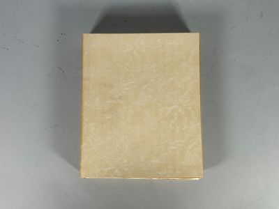 une petite boîte de savon posée sur une surface blanche