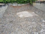 un gros tas de gravier posé par terre près d'un mur
