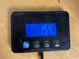 a digital clock on a wooden table with a cord