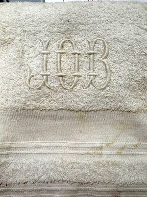towel with a monogram on it sitting on top of a bed