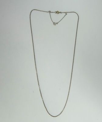 a close up of a necklace on a white surface with a white background