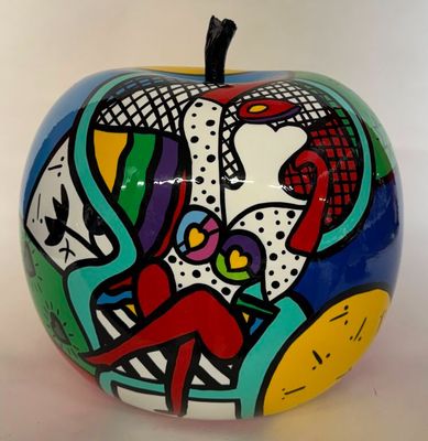 une pomme colorée, ornée d'une peinture, posée sur une surface blanche