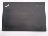 a black laptop on a white surface with a sticker on it