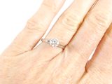 a woman ' s hand with a diamond ring on it