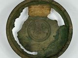 an old metal object with a hole in the middle of it