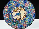 a colorful plate with a bird on it on a stand