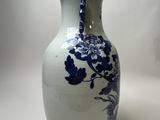 a blue and white vase sitting on a white table
