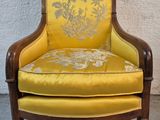 une chaise jaune posée devant un mur blanc