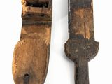 pair of old wooden tools on a white surface with a white background