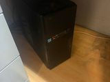 a small black computer sitting on a wooden desk