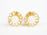 une paire de boucles d'oreilles en forme de fleurs dorées et blanches sur fond blanc