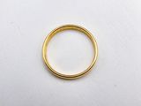 a close up of a gold wedding ring on a white surface