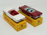 two toy cars sitting on top of boxes on a table