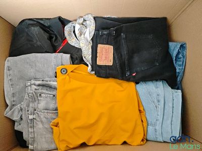 a cardboard box filled with clothes and a bag