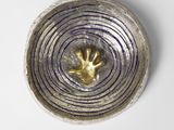 un bol en argent orné d'une grenouille en or au centre