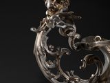 a silver tea pot with a handle on a black background