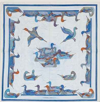 une photo d'une couette bleue et blanche ornée d'oiseaux
