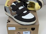 black and white sneakers with leopard print on them sitting on top of a cardboard box