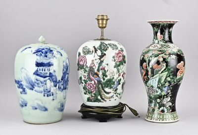 Trois vases sont posés sur une table, surmontée d'une lampe