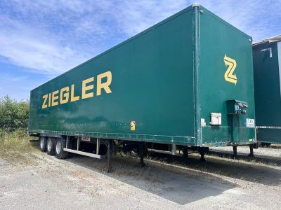 un semi-remorque vert garé sur le bord de la route