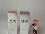 perfume bottle and keychain sitting on a white surface next to each other