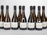 six bouteilles de vin sont alignées sur une table