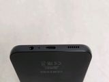 a close up of the back of a black cell phone on a white surface