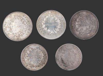 six pièces d'argent de tailles et de formes différentes sur fond noir