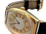 a gold wrist watch with a black strap around it