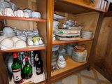 de nombreuses assiettes et tasses sur les étagères de la cuisine