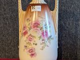 un vase muni d'une anse décorée de fleurs