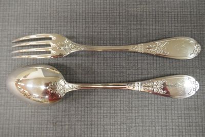 deux cuillères et une fourchette en argent sur une table