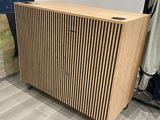 un gros plan sur une armoire en bois dans un magasin, avec des vêtements suspendus à des cintres
