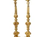 a pair of gold candlesticks on a white background
