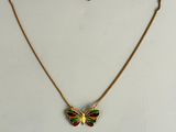 un collier en or orné d'un papillon vert et rouge