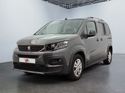 La camionnette grise est garée dans une grande pièce d'un immeuble.