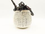 a white vase with writing on it with a spoon in it