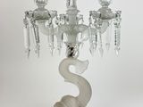 un chandelier en verre surmonté d'un dragon
