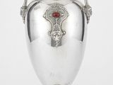 une image représentant un vase en argent contenant une pierre rouge