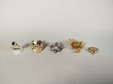 four different pieces of jewelry sitting on top of a white surface