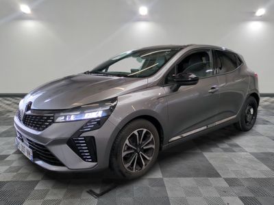 Une voiture argentée est garée sur un sol à damier dans un showroom.