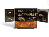 a black and gold chest with four drawers on it