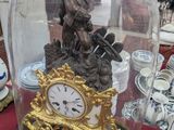 une horloge posée sur une table, sous un dôme en verre
