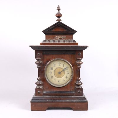 une horloge en bois posée sur une surface blanche
