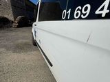 a white van parked in a parking lot with a building in the background