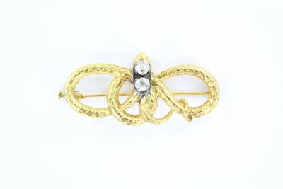 un gros plan sur une broche en or et diamants