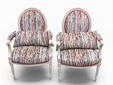 deux chaises blanches sur lesquelles sont posés des coussins rembourrés à rayures colorées